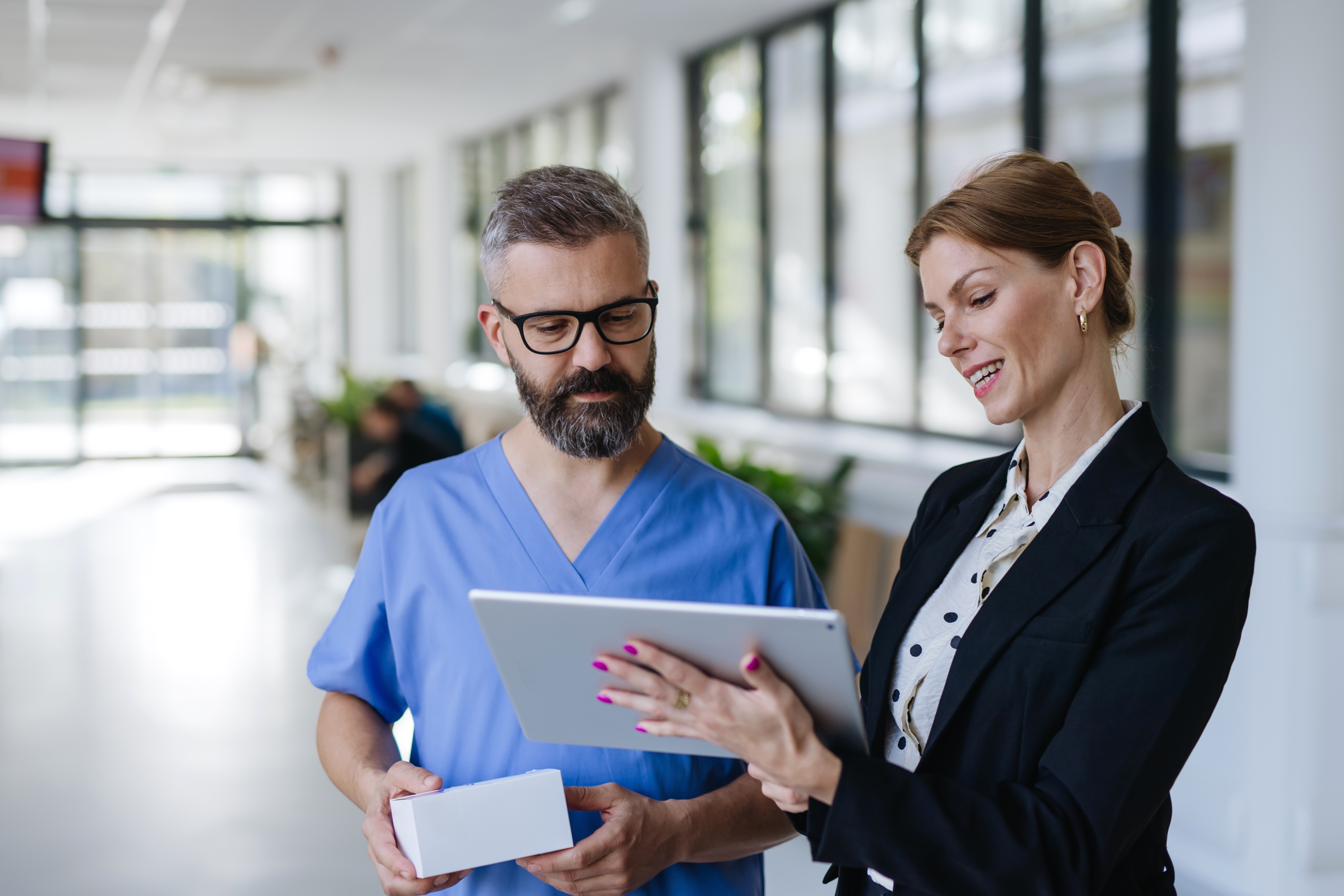 A doctor and a nurse are discussing the dosage for B. Braun smart infusion, which is being directly input from a tablet. 