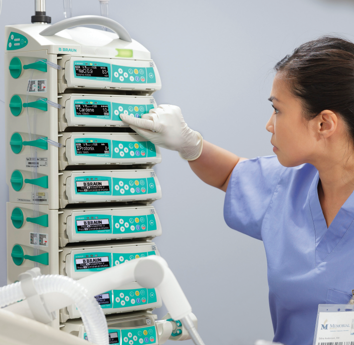 Alt Text: A close-up of a nurse standing as she programs a B. Braun SpaceStation.